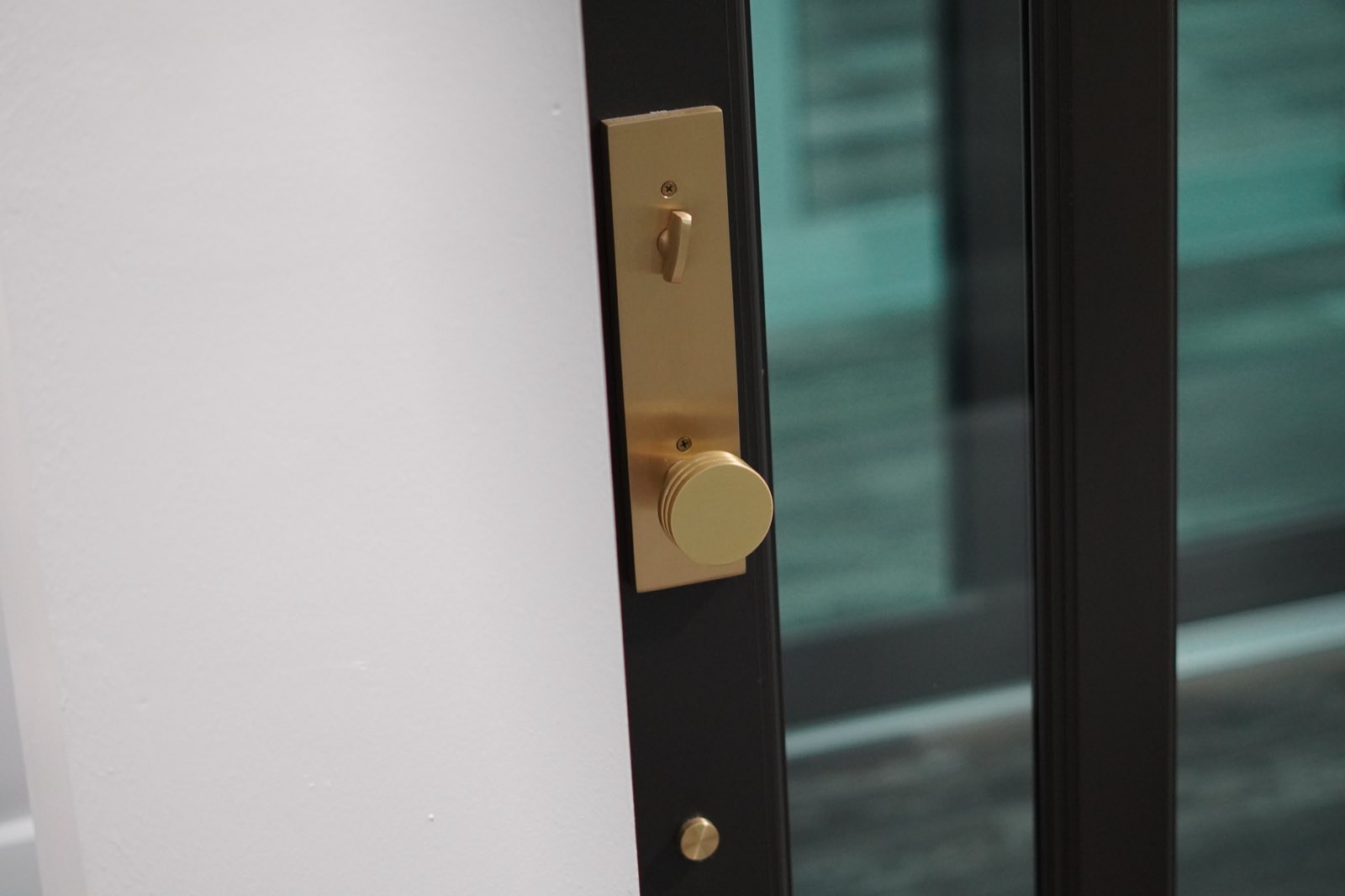 Close-up of a brass handle and multi-point lock on a black impact door