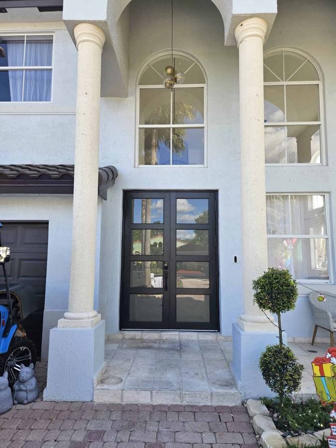 Black French doors between columns
